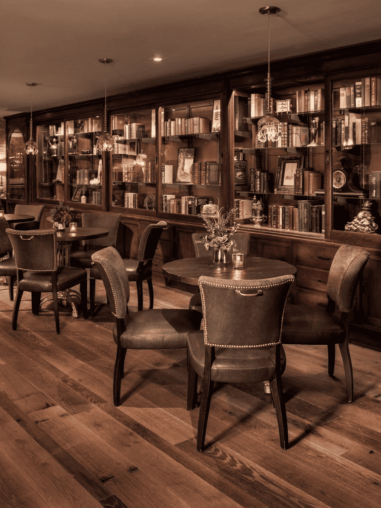 Elegant vintage library lounge with dark wood bookshelves and cozy seating for relaxing reading.