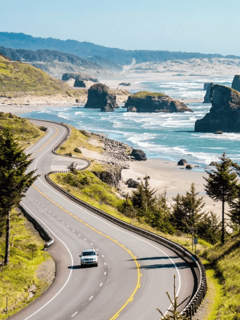 Seaside coastal highway with ocean cliffs and winding road along rugged coastline.