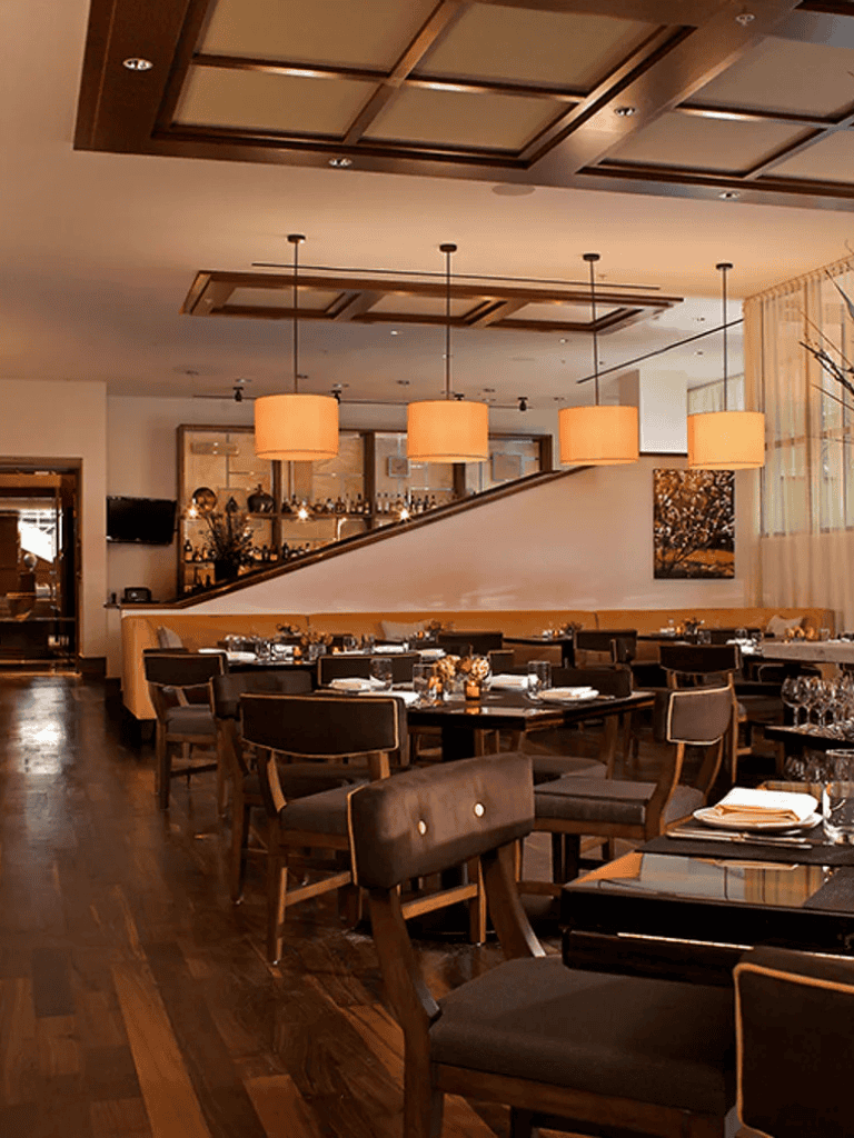 Modern restaurant dining area with warm lighting and elegant decor for a fine dining experience.