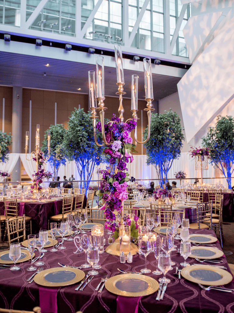 Elegant banquet setting with floral centerpieces and candlelit chandeliers for upscale events.