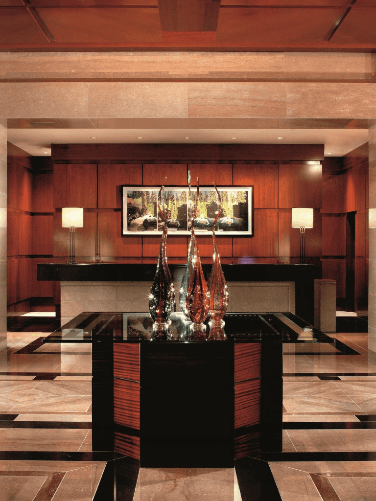 Elegant hotel lobby with modern decorative vases, warm wood paneling, and ambient lighting for a luxurious feel.