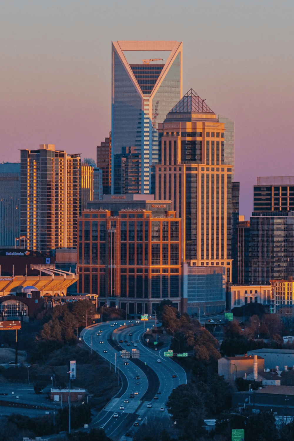 Modern Dallas skyline with downtown skyscrapers and highways at sunset.
