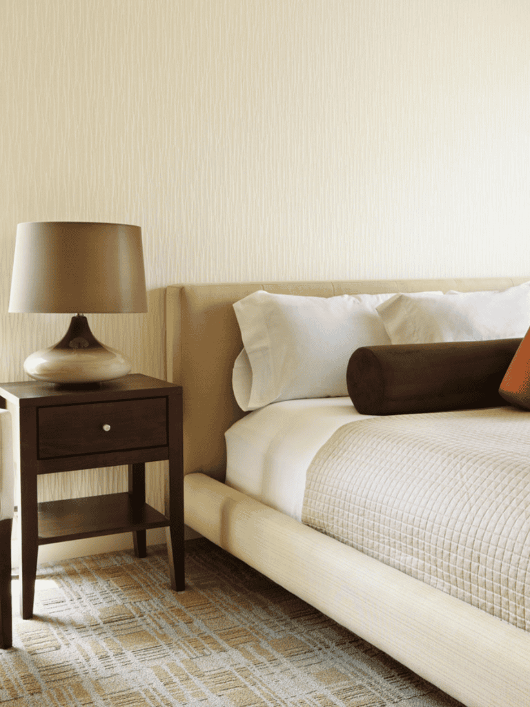 Cozy bedroom with side table and lamp, stylish interior design, comfortable bedding, QuestForDirections hotel ambiance.