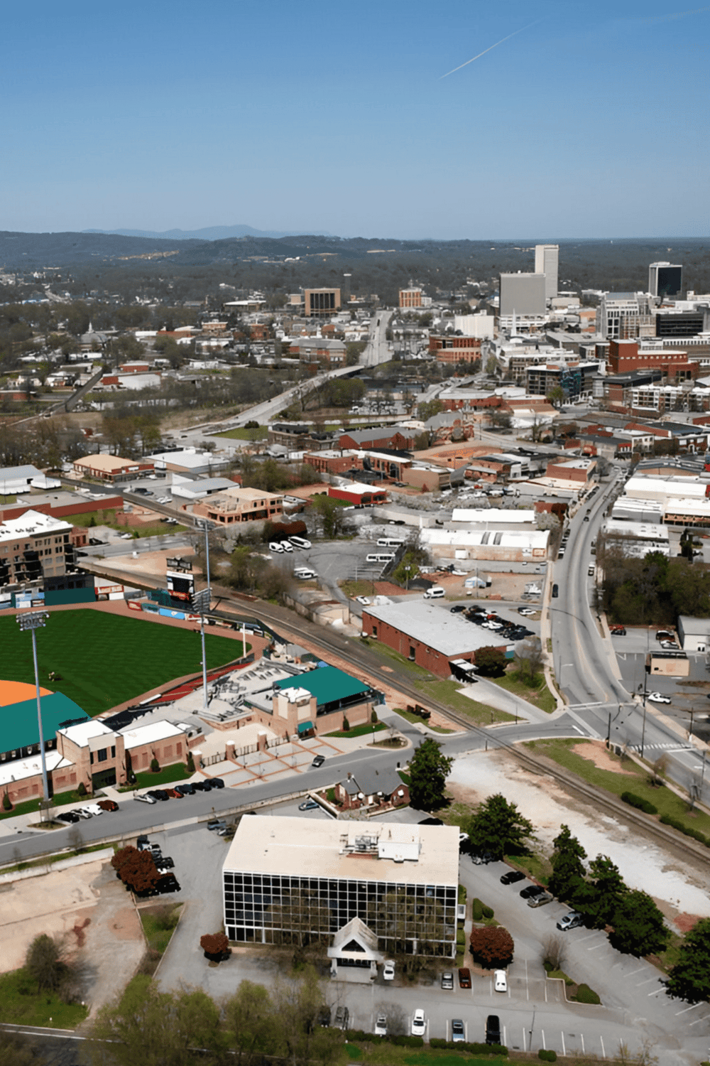 Aerial view of downtown with skyline, stadium, and surrounding cityscape, highlighting QuestForDirections services.