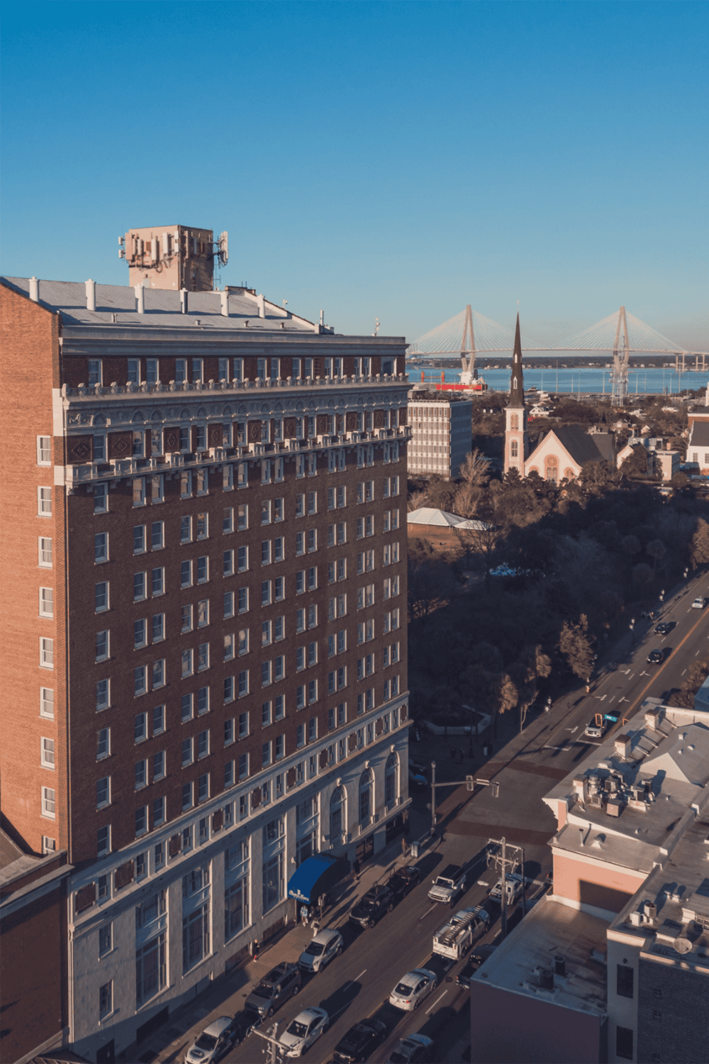 Modern cityscape with a high-rise building, river, and bridge in the background.