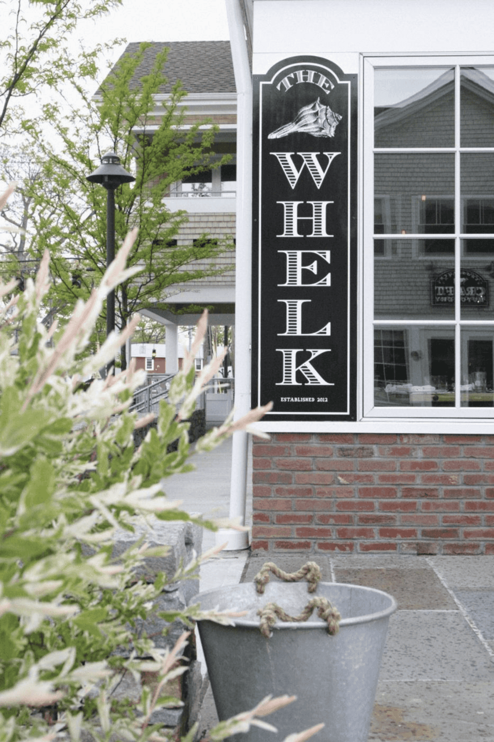 Warm Welcome Sign for The Whelk Restaurant, established 2012, offers a cozy dining experience in a charming neighborhood.