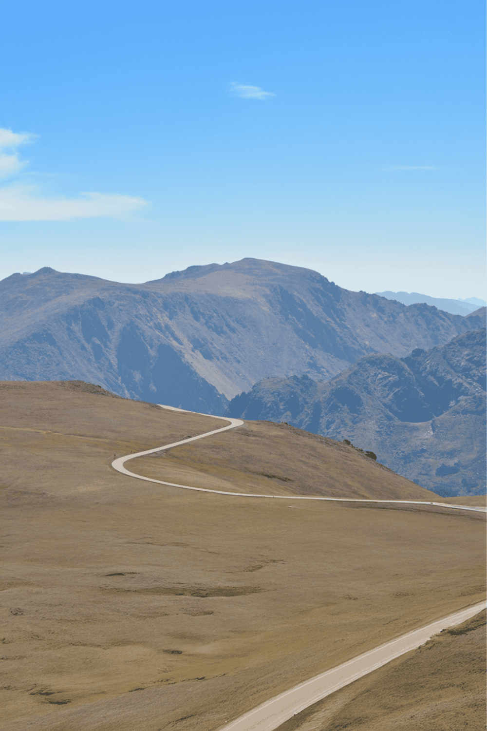 Winding mountain road through rugged landscape, scenic views, and open terrain.