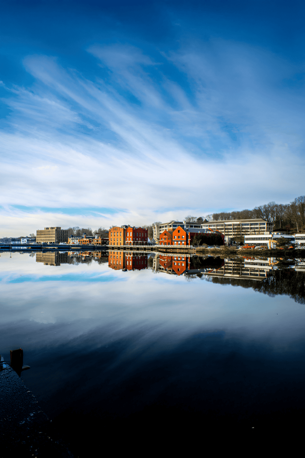Panoramic view of waterfront city with colorful buildings and blue sky.