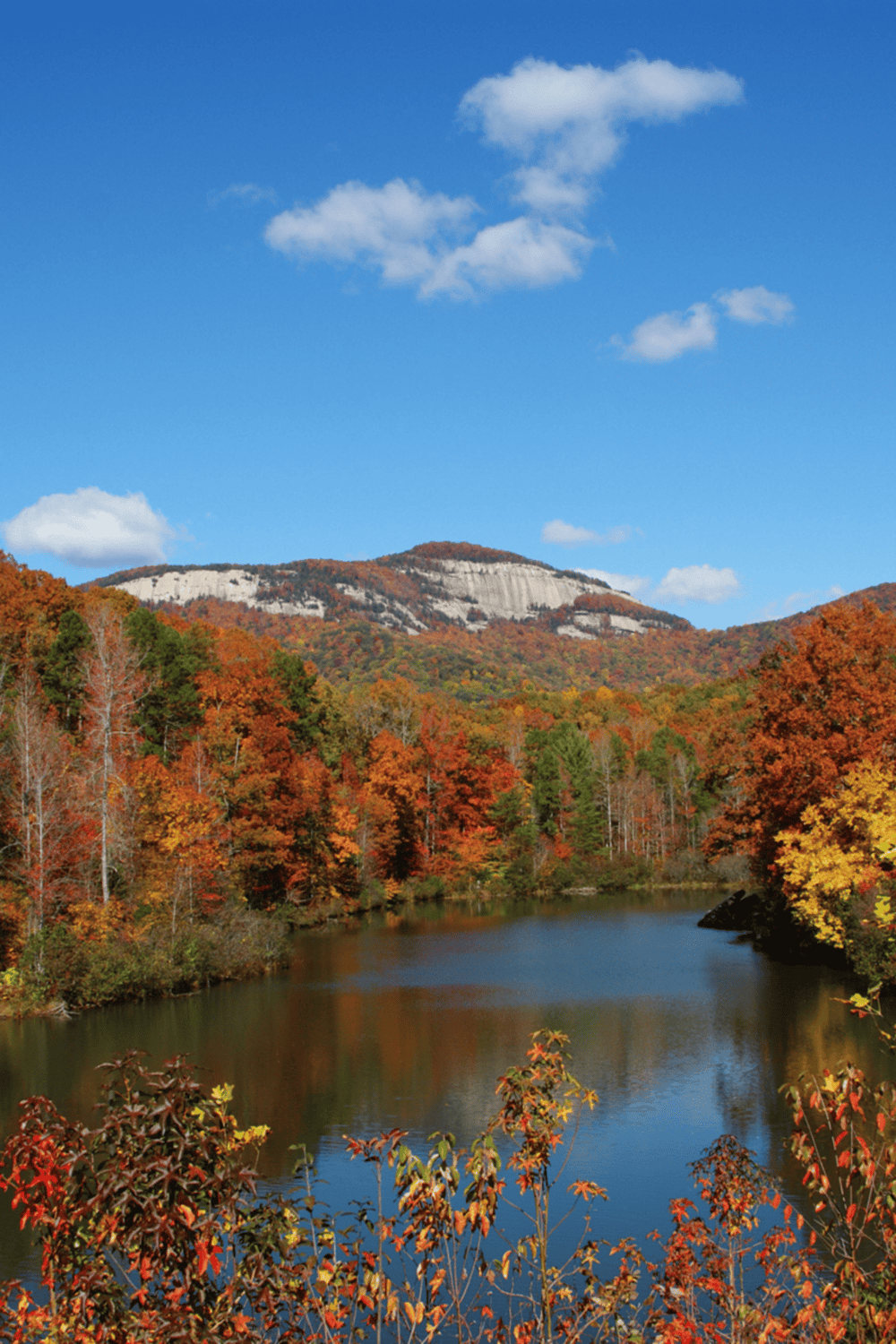 Colorful fall foliage with a mountain and river scene for outdoor adventure and nature exploration.