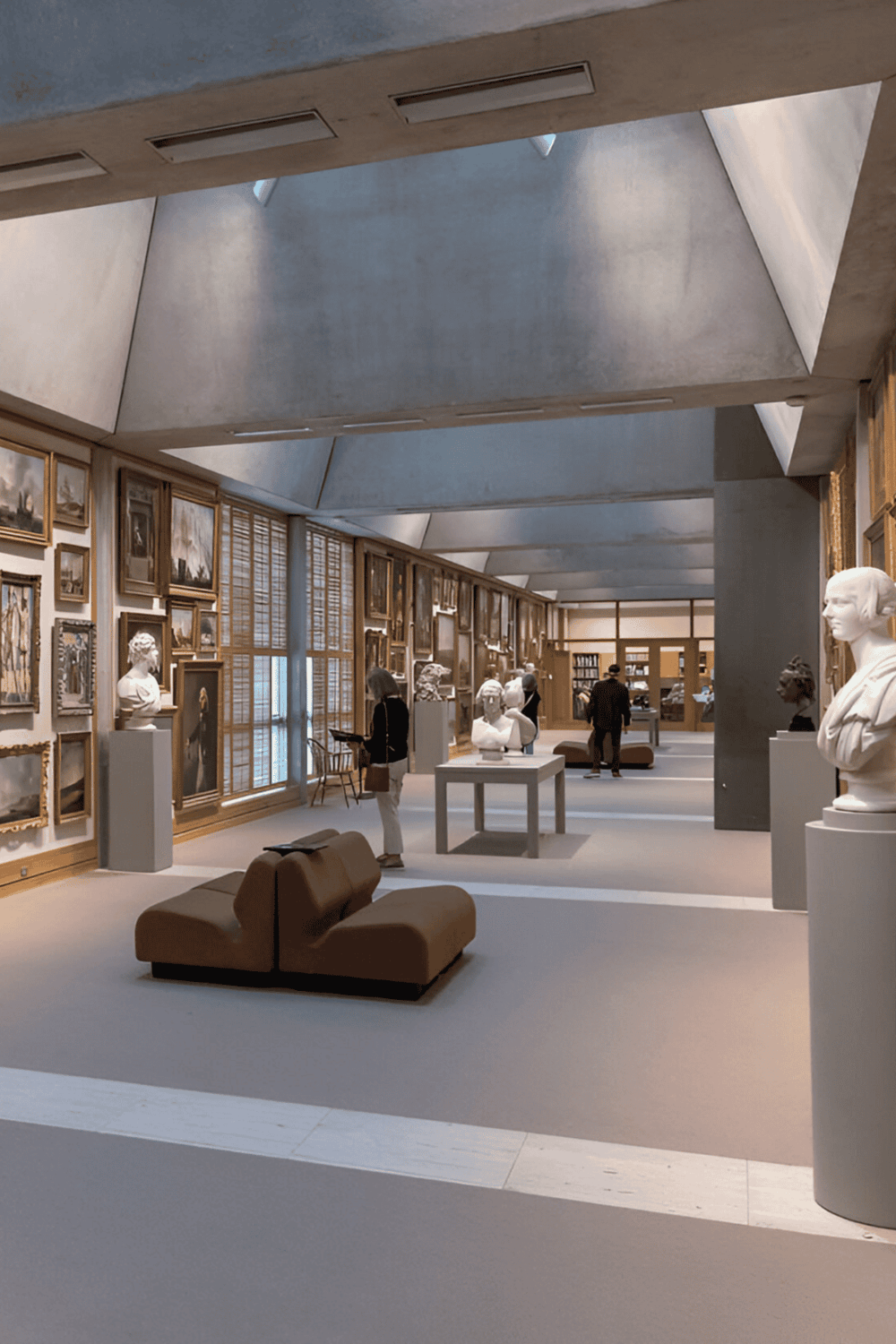 Statue and art gallery interior, museum displaying classical sculptures and paintings, contemporary architecture and elegant exhibit space.