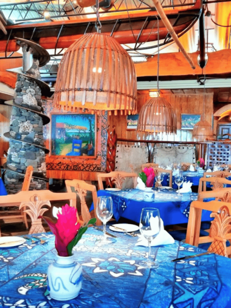Colorful tropical restaurant interior with wooden decor and island art, perfect for dining experiences.