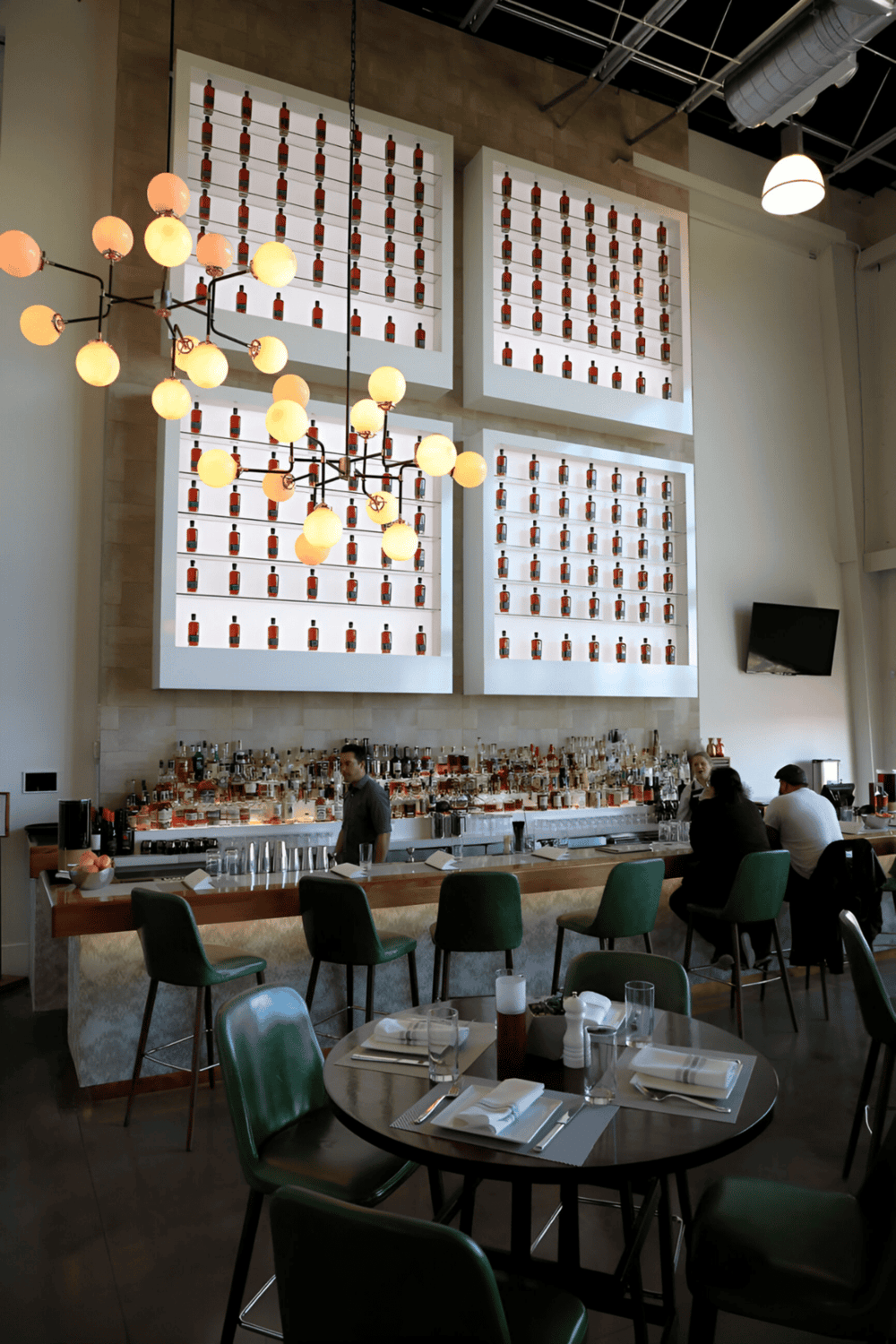 High-end bar interior with wall art, modern lighting, and cozy seating - perfect for a craft cocktail experience.