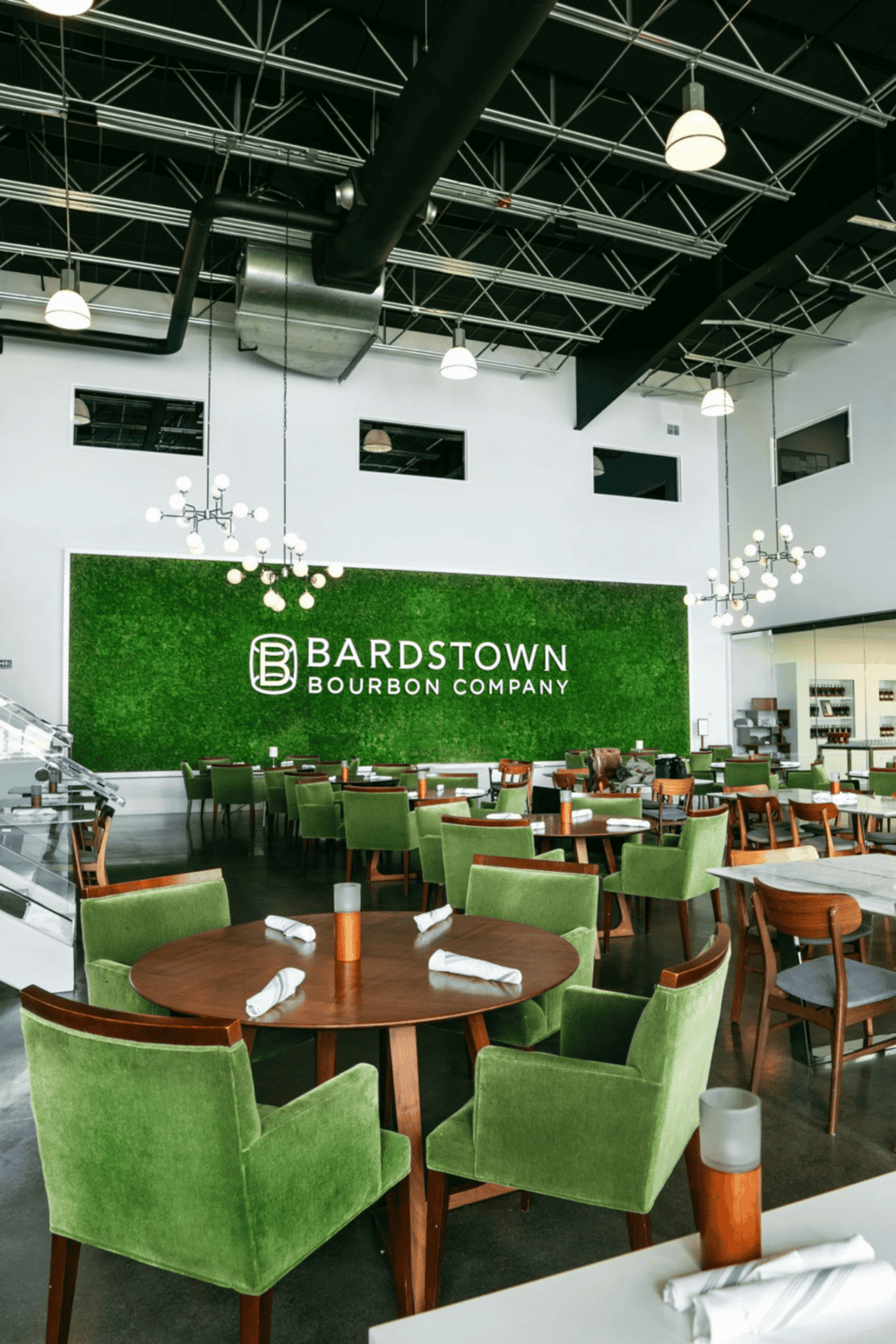 Modern bourbon tasting room with green accents and stylish lighting.