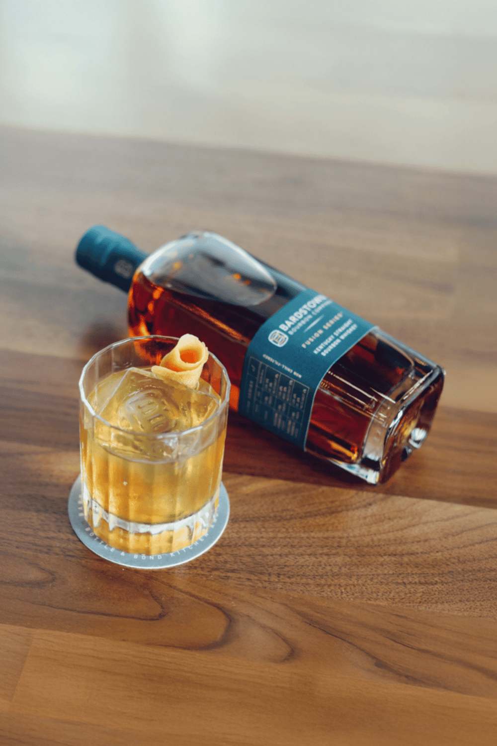 Premium whiskey bottle with a glass of ice on a wooden table, luxury spirits and fine drinking experience.