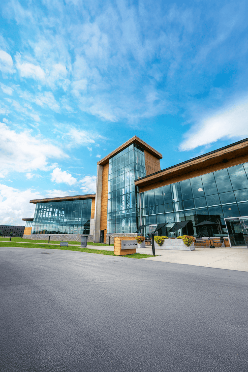 Modern corporate office building with glass façade and clear blue sky.