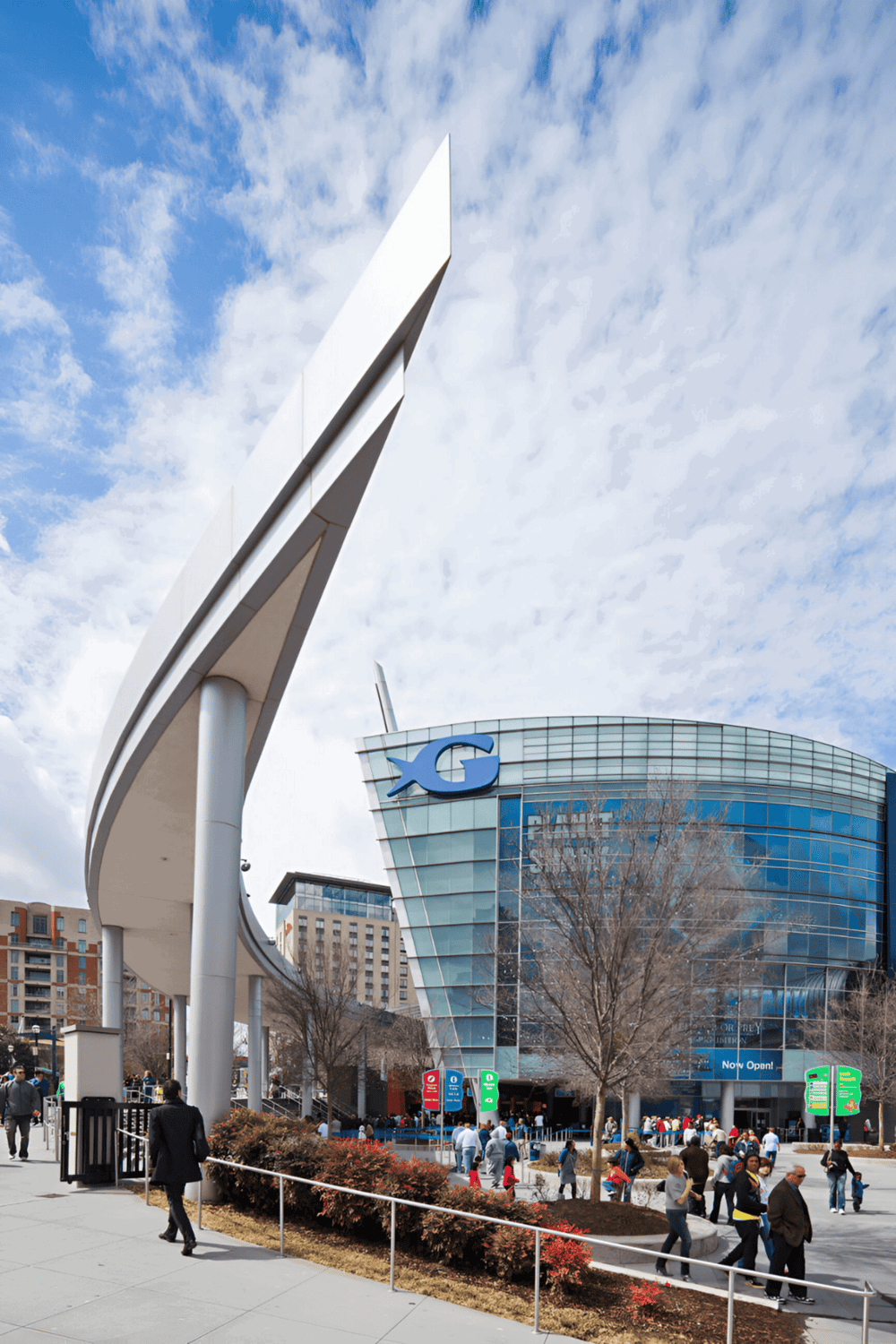 Modern shopping mall exterior with dynamic architecture and outdoor crowd.