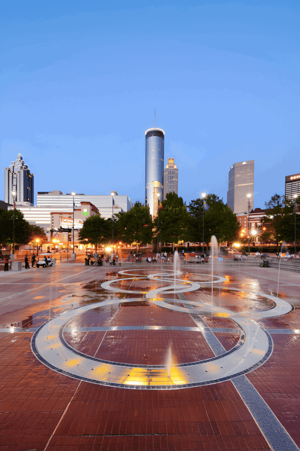 Fountain in downtown Dallas with city skyline at sunset.