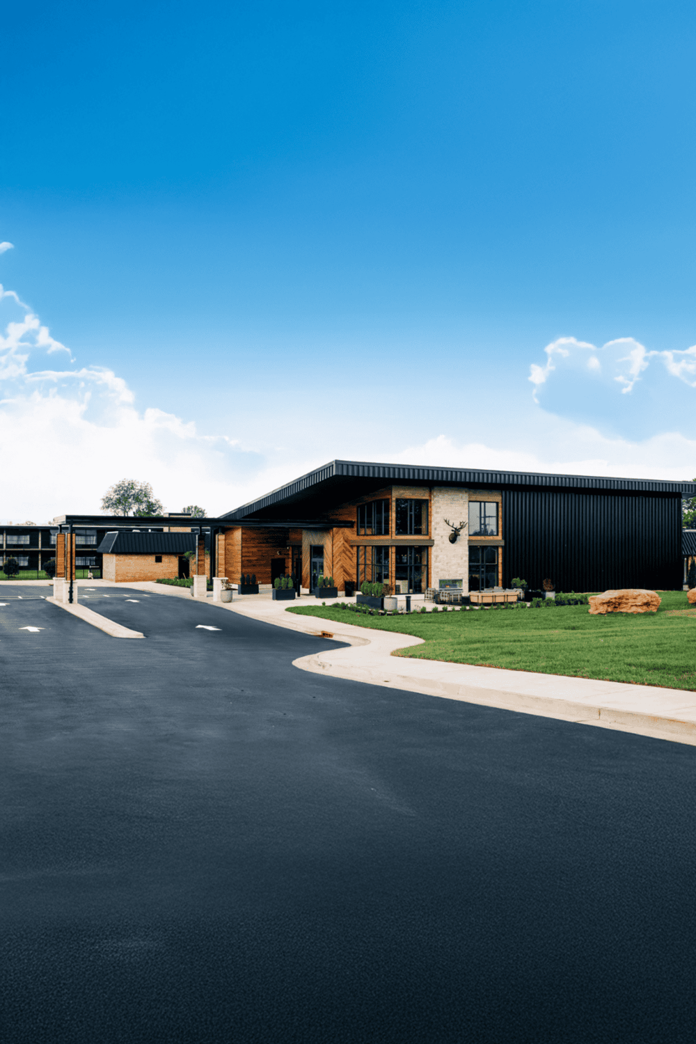 Modern building with QuestForDirections signage, outdoor parking, and welcoming entrance.