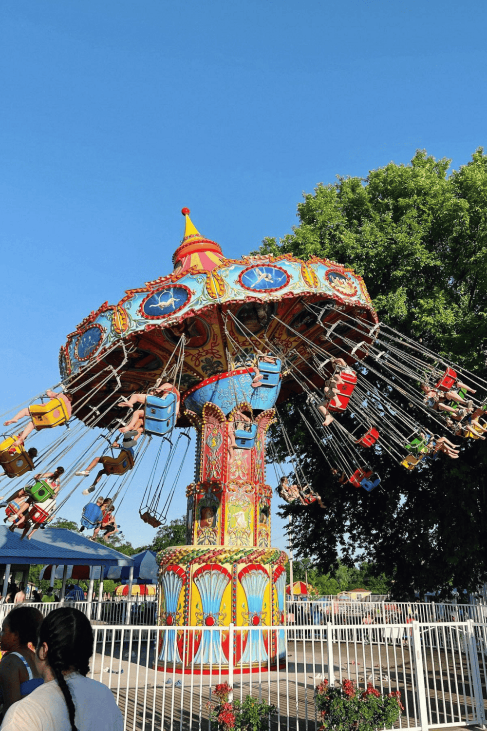 Colorful amusement park swing ride with children enjoying the carnival atmosphere.
