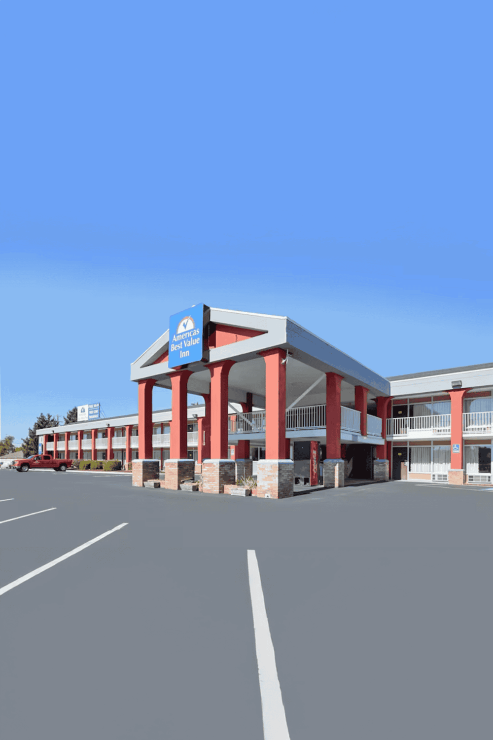 Americas Best Value Inn hotel exterior with parking lot and clear blue sky, ideal for travel and accommodation SEO.