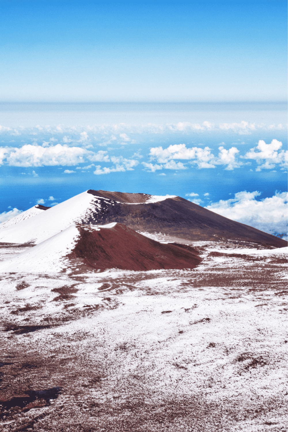 Snow-capped volcano in the clouds, part of QuestForDirections' scenic outdoor adventures.
