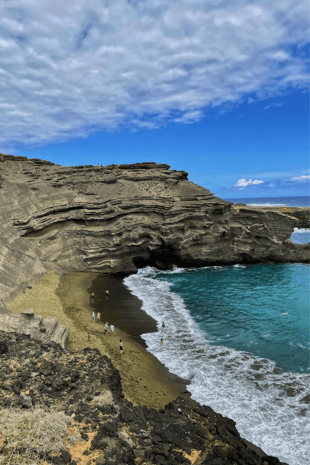 Secluded beach with rock formations and natural arch at Tongue Point, Kauai, Hawaii. Stunning coastal scenery and blue ocean.