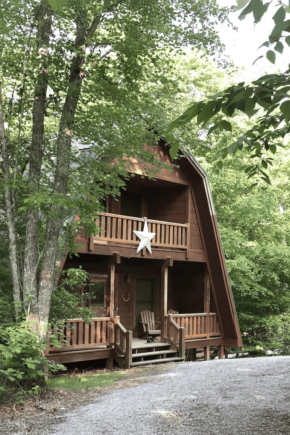 Cozy A-frame cabin surrounded by lush green trees in a serene forest setting.
