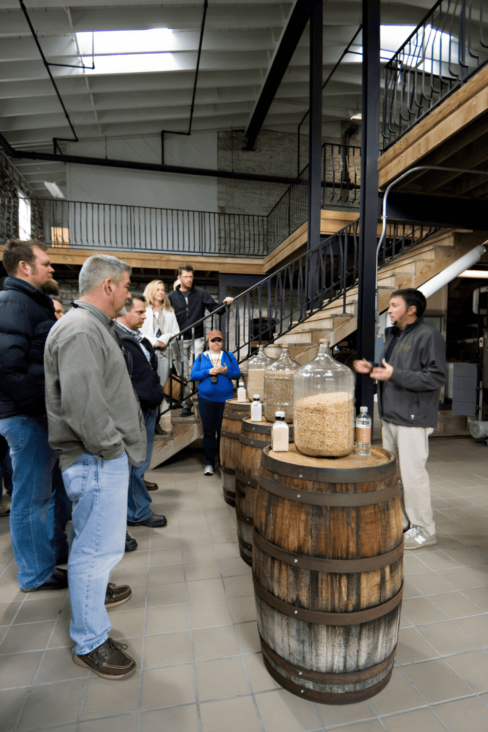Whiskey tasting seminar at QuestForDirections distillery with guide explaining to a group of customers.