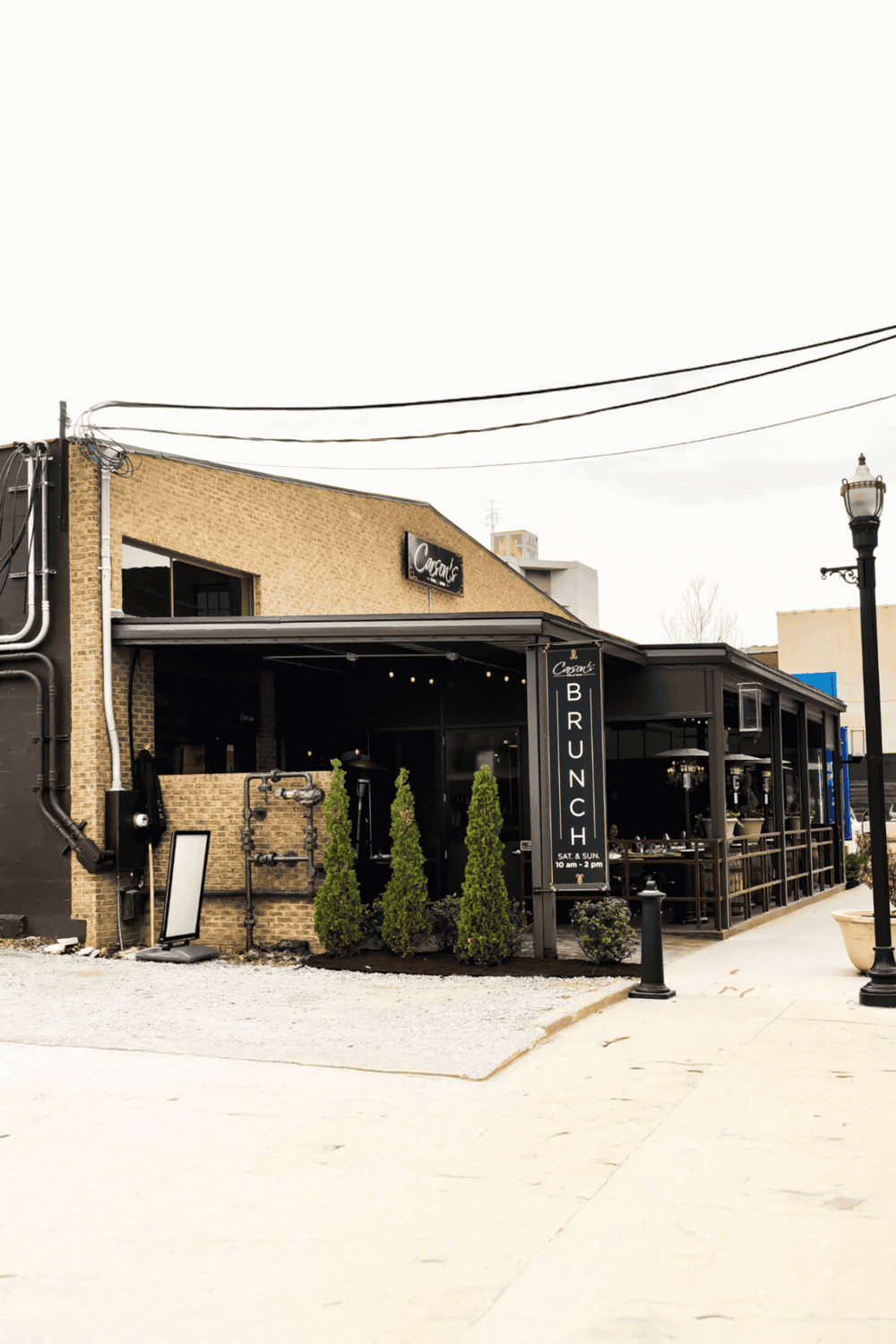 Cozy brunch restaurant exterior with black awning and outdoor seating area, located in downtown district.