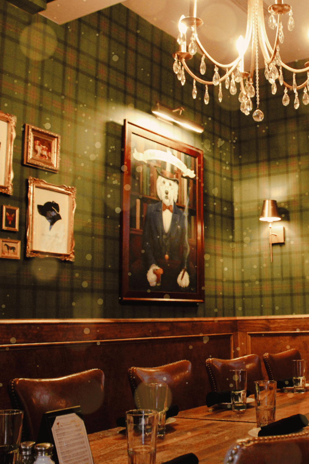 Elegant restaurant interior with vintage artwork, chandelier lighting, and cozy dining ambiance.