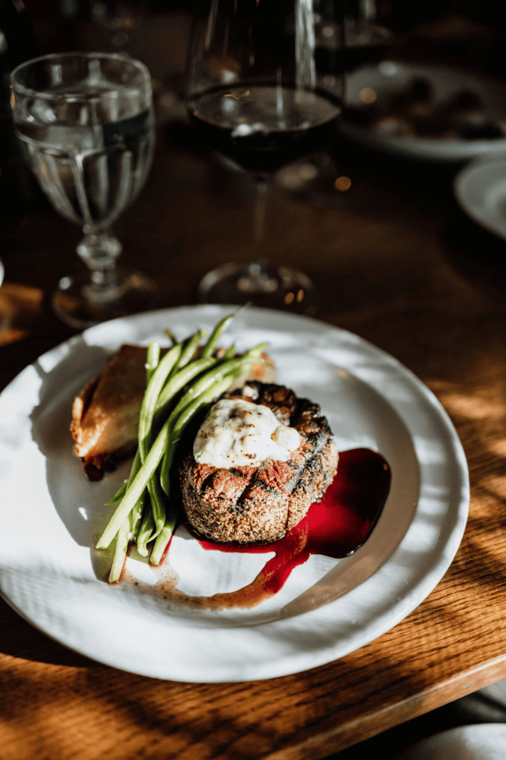 Gourmet steak dish with vegetables and red wine sauce at QuestForDirections restaurant.