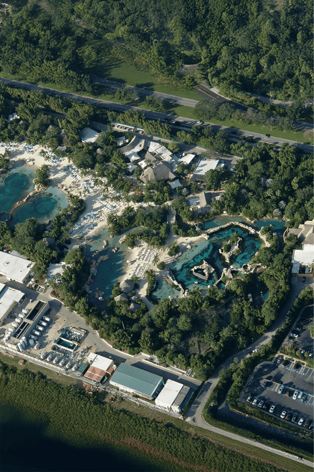 Water park with slides and pools surrounded by greenery and amenities.