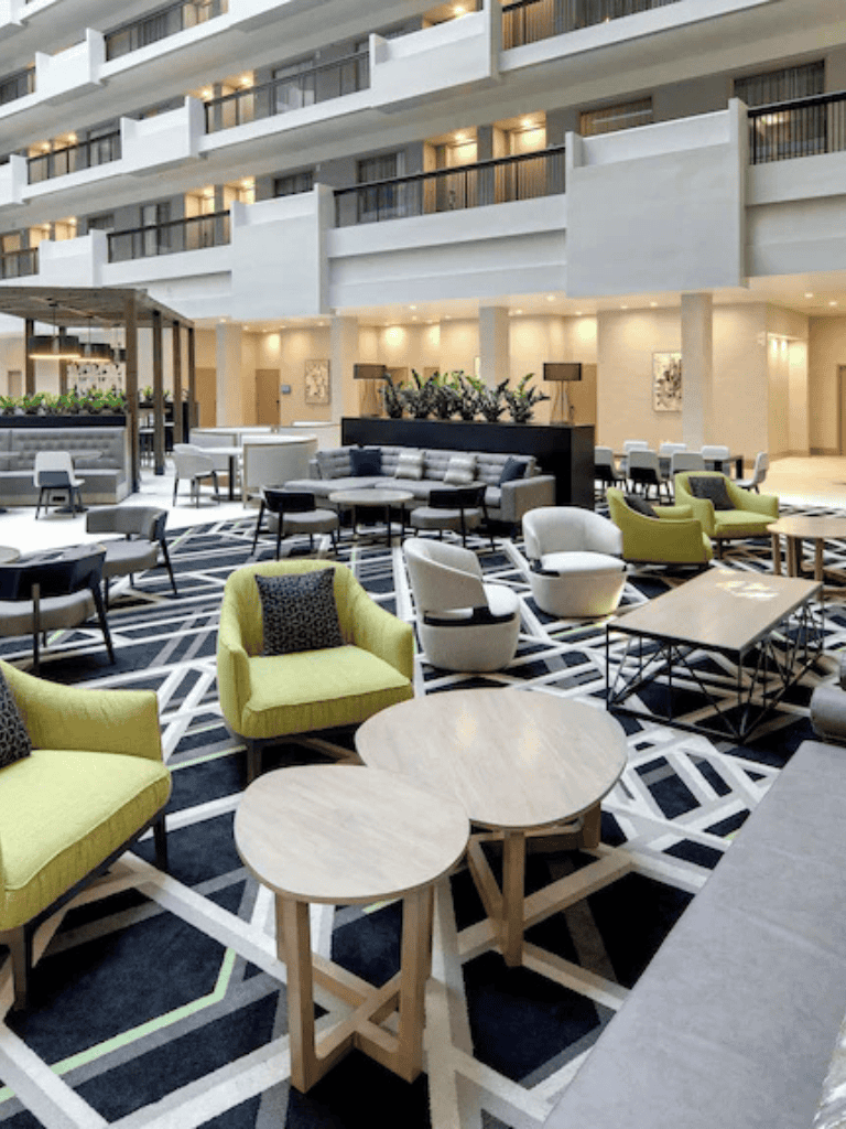 Modern hotel lobby with contemporary furniture, vibrant seating, and stylish decor for a comfortable guest experience.