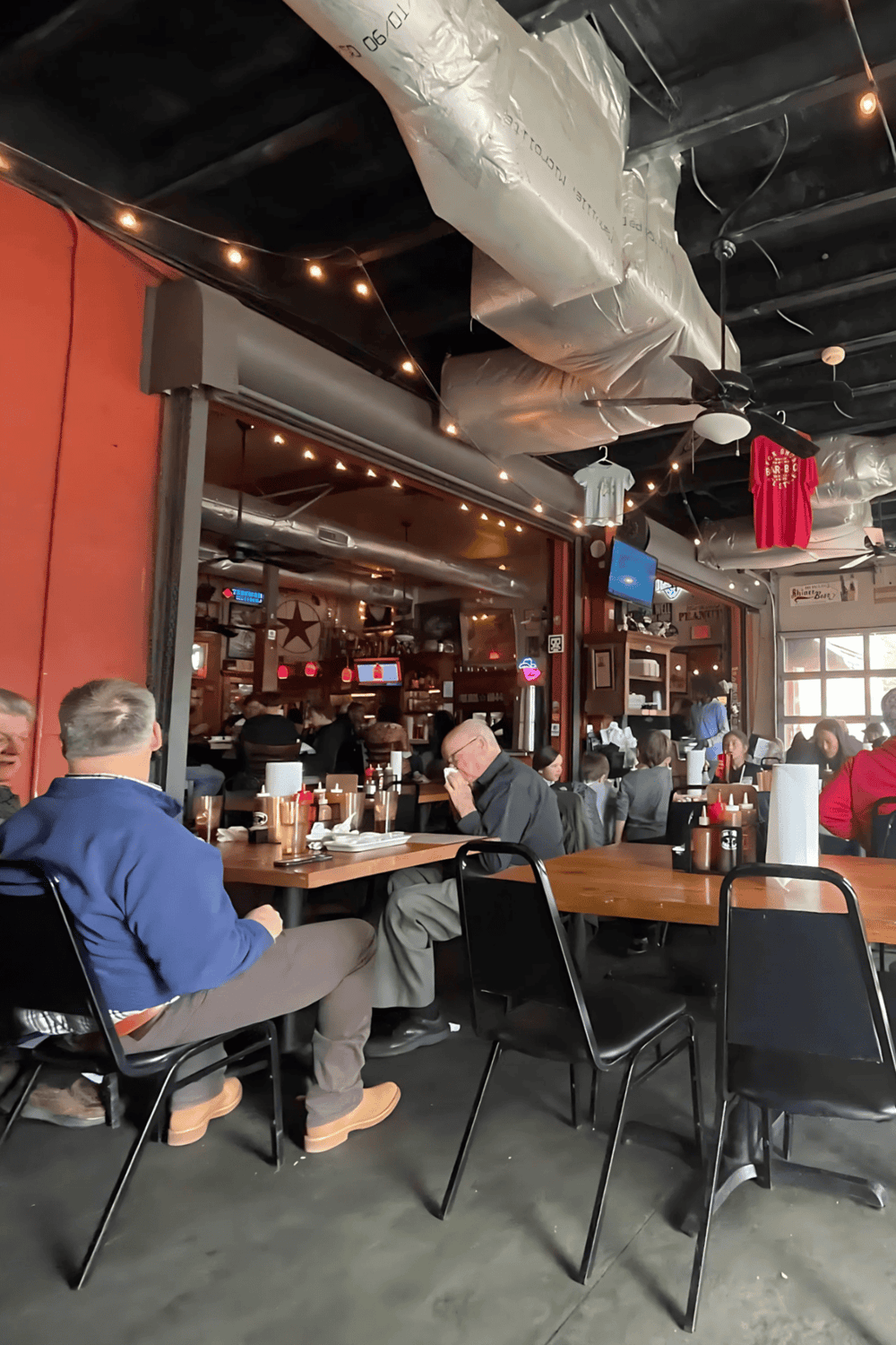 Cozy restaurant interior with casual dining atmosphere, wood tables, and ambient lighting.