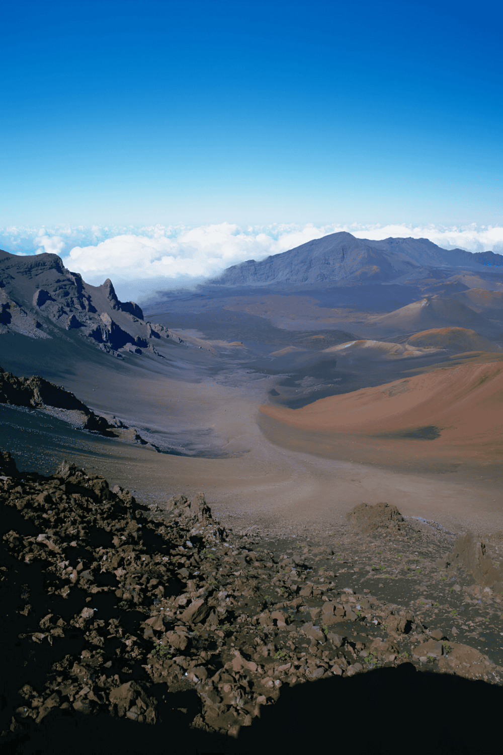 Breathtaking volcanic crater landscape with rugged terrain and distant volcanic peaks.