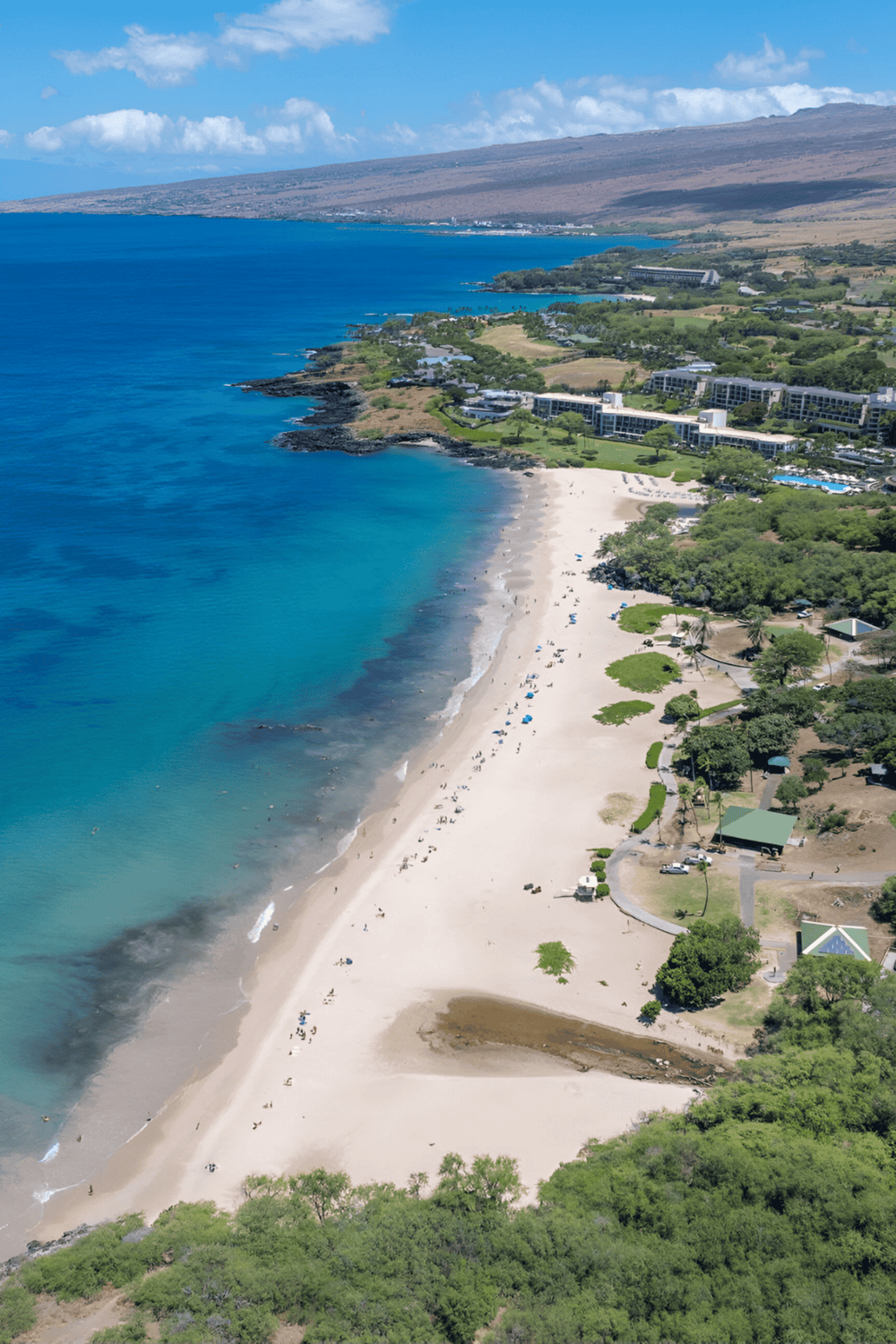 Scenic beachfront with white sand, turquoise waters, and lush greenery, part of Quest for Directions' scenic coastal destinations.