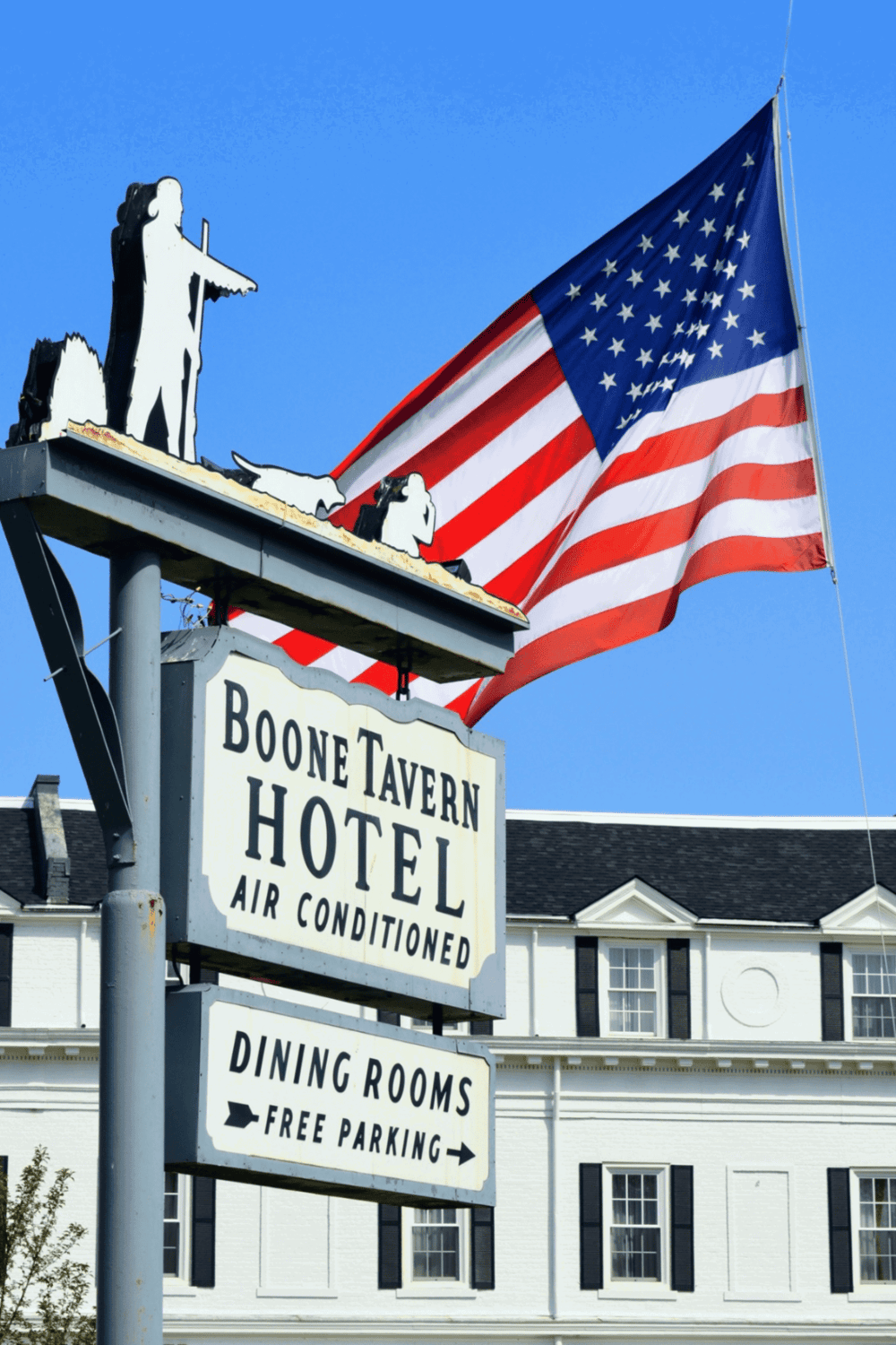 American flag outside Boone Tavern Hotel with classic sign and historic building.