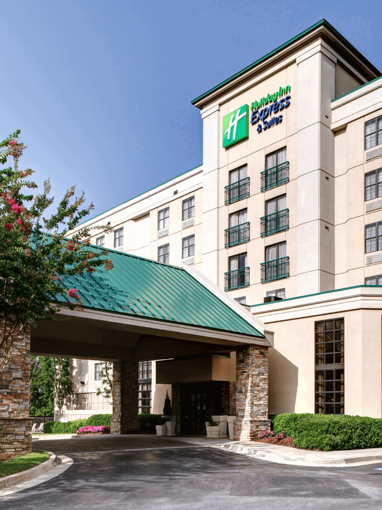 Holiday Inn Express & Suites hotel exterior with welcoming entrance and parking area, ideal for travelers seeking comfort and convenience.