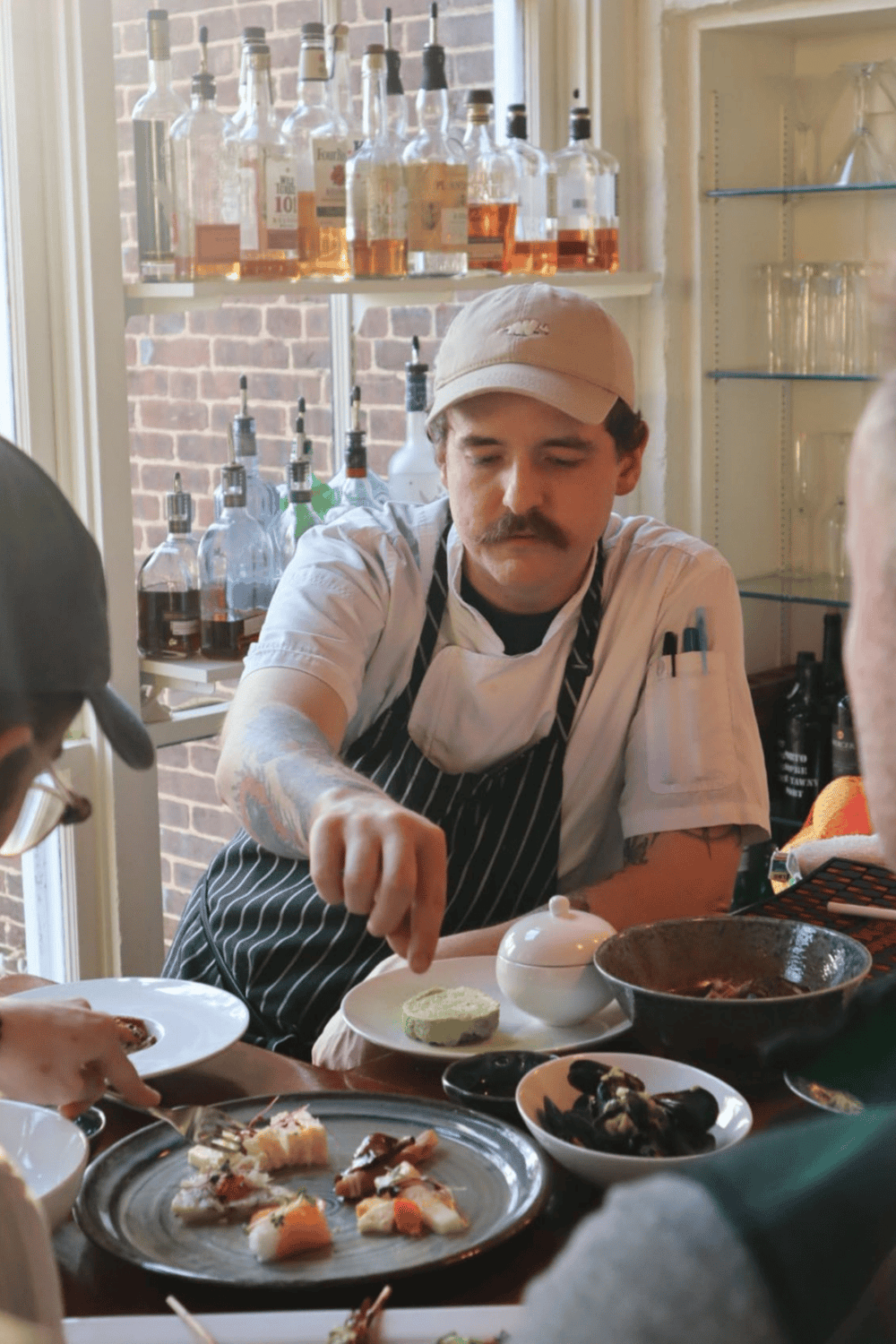 Freshly prepared gourmet dishes in a cozy restaurant setting with a skilled chef.