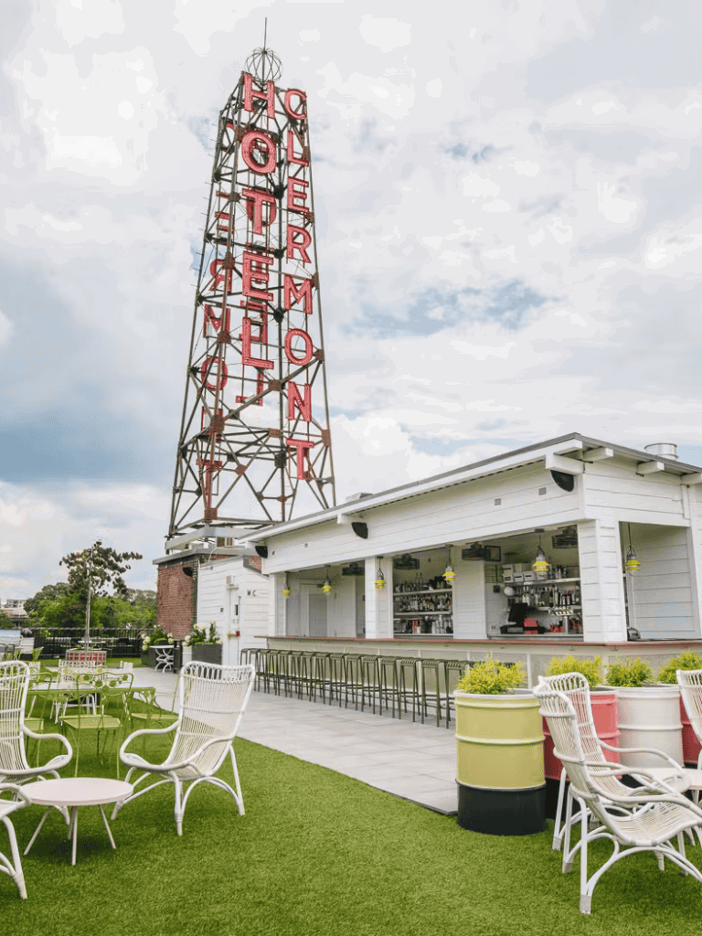 Old Hotel Monty sign, vintage outdoor bar, stylish seating, lively rooftop atmosphere, Quest for Directions venue.