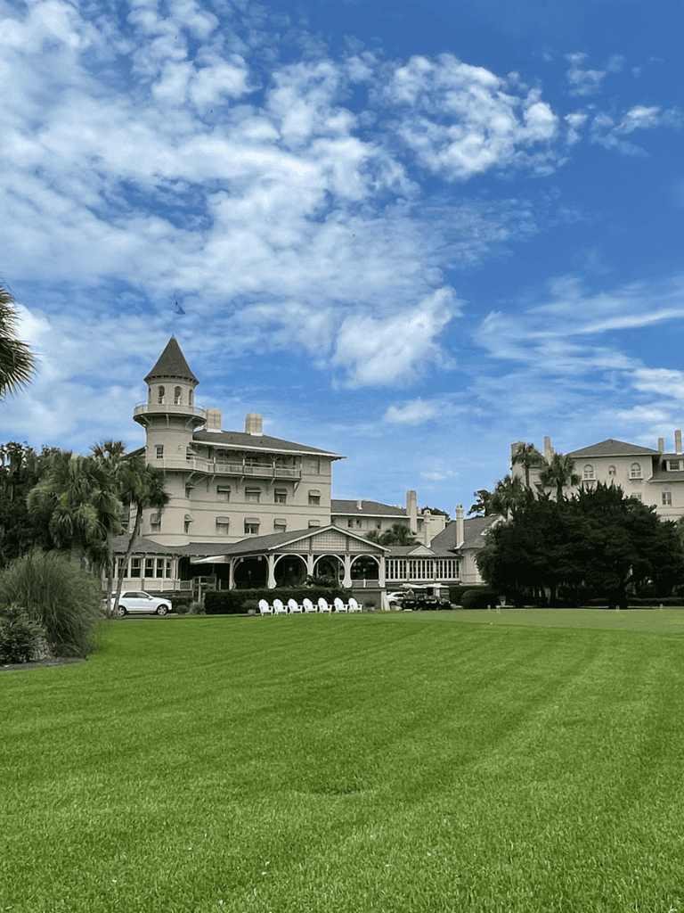 Elegant historic hotel with lush green lawns and scenic sky views for relaxing stays.