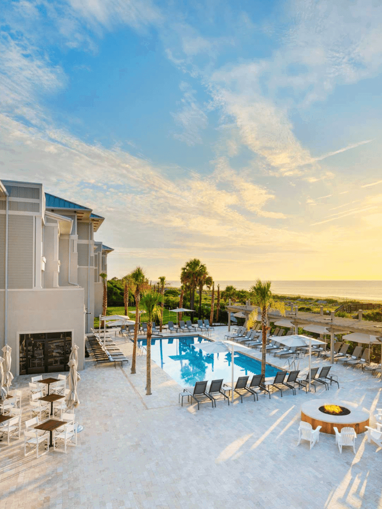 Luxurious beachside resort with pool and palm trees, perfect for vacation and relaxation.