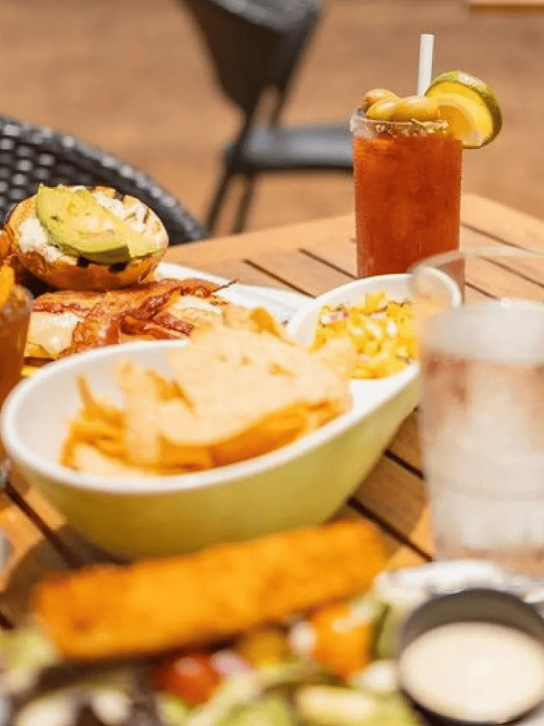 Crispy potato chips and flavorful tacos on a wooden table with refreshing drinks, ideal for casual dining.