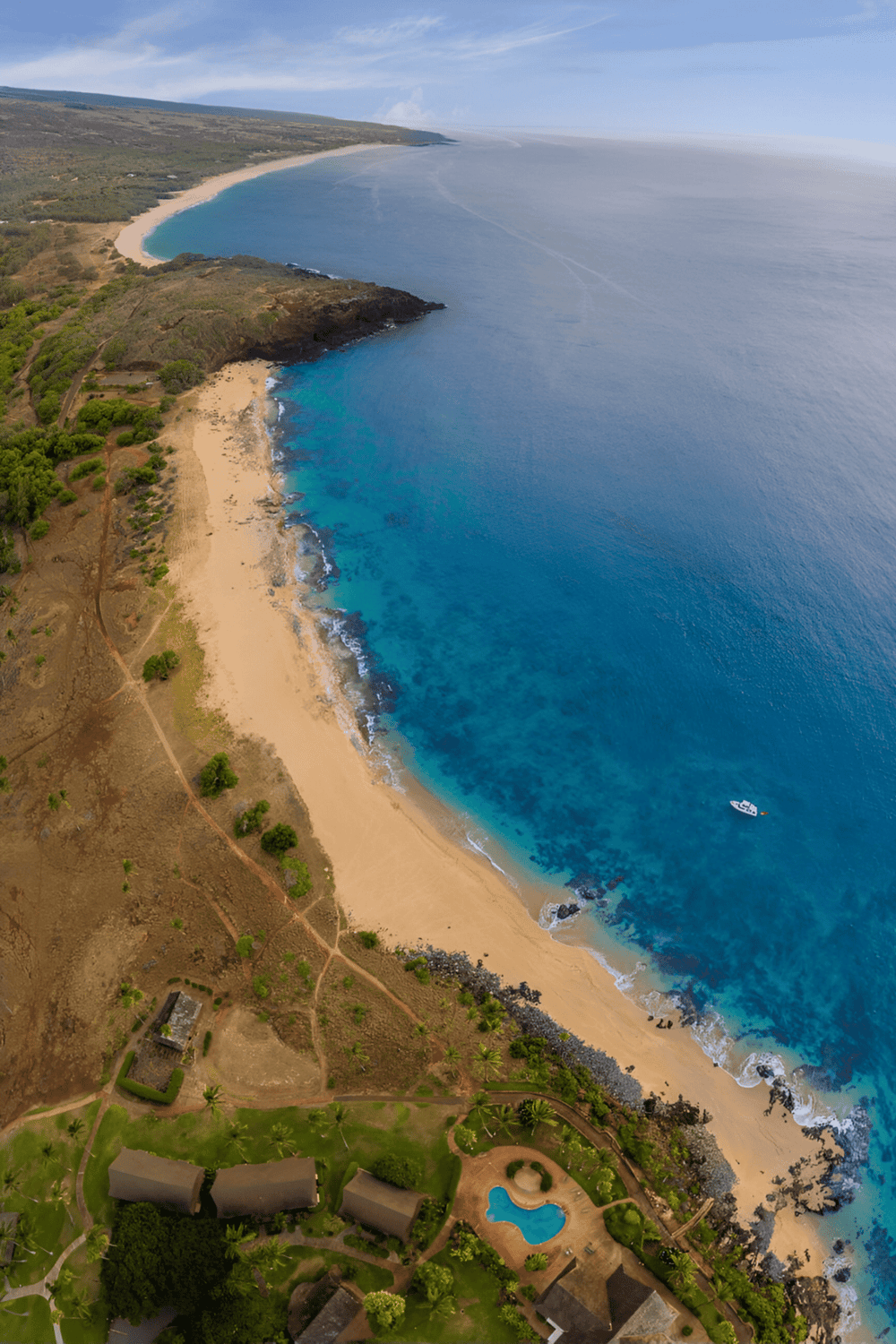 Vibrant coastal view of a tropical beach with clear blue waters and lush greenery, perfect for travel and adventure.