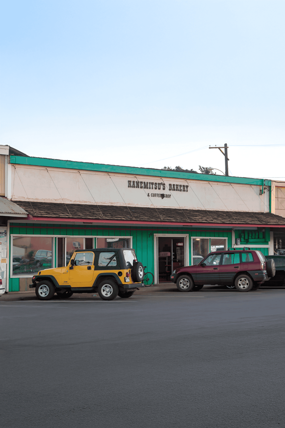 Vintage bakery storefront with parked cars, showcasing local eateries and community charm.