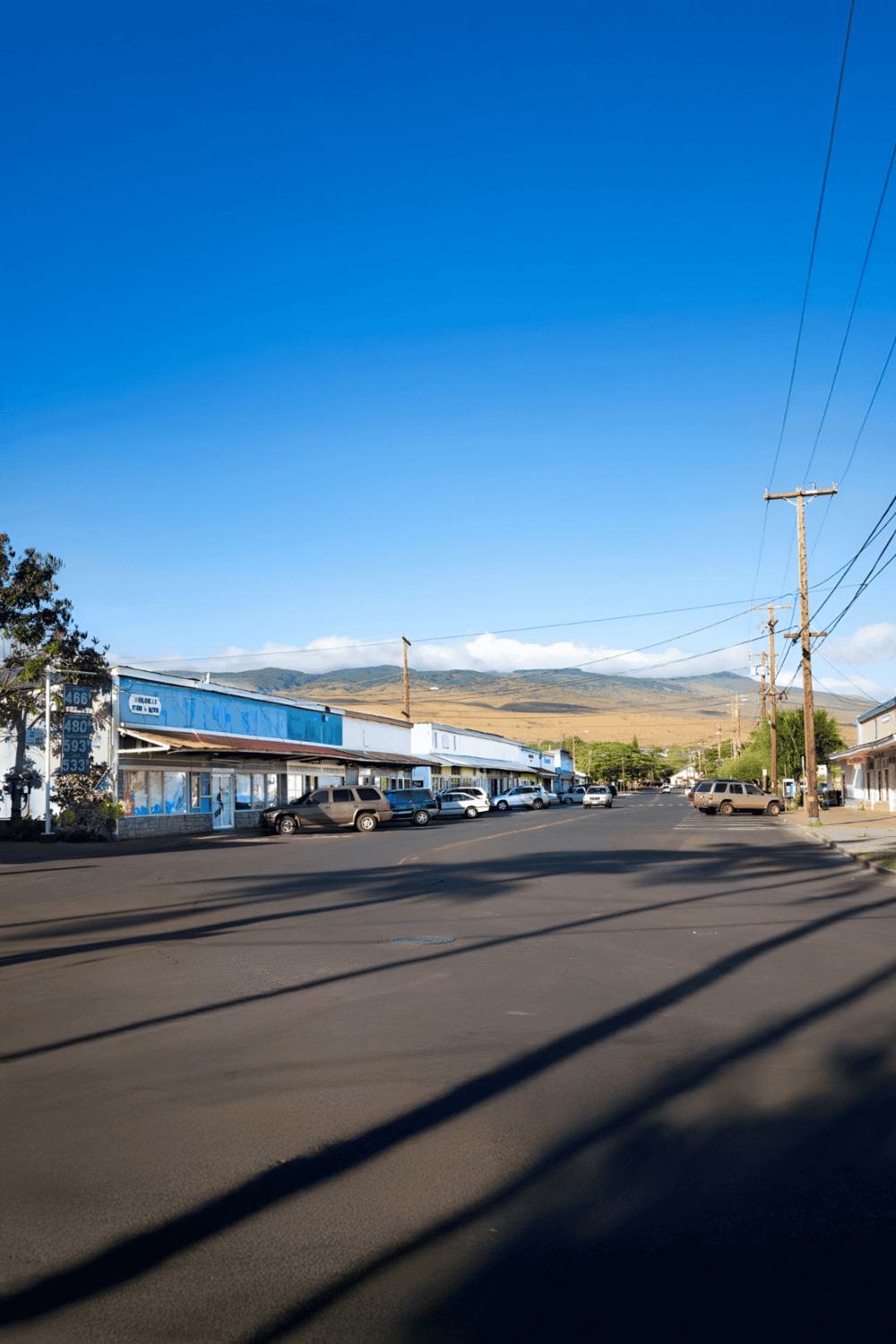 Quiet downtown street with shops and mountain view, perfect for travelers seeking directions.