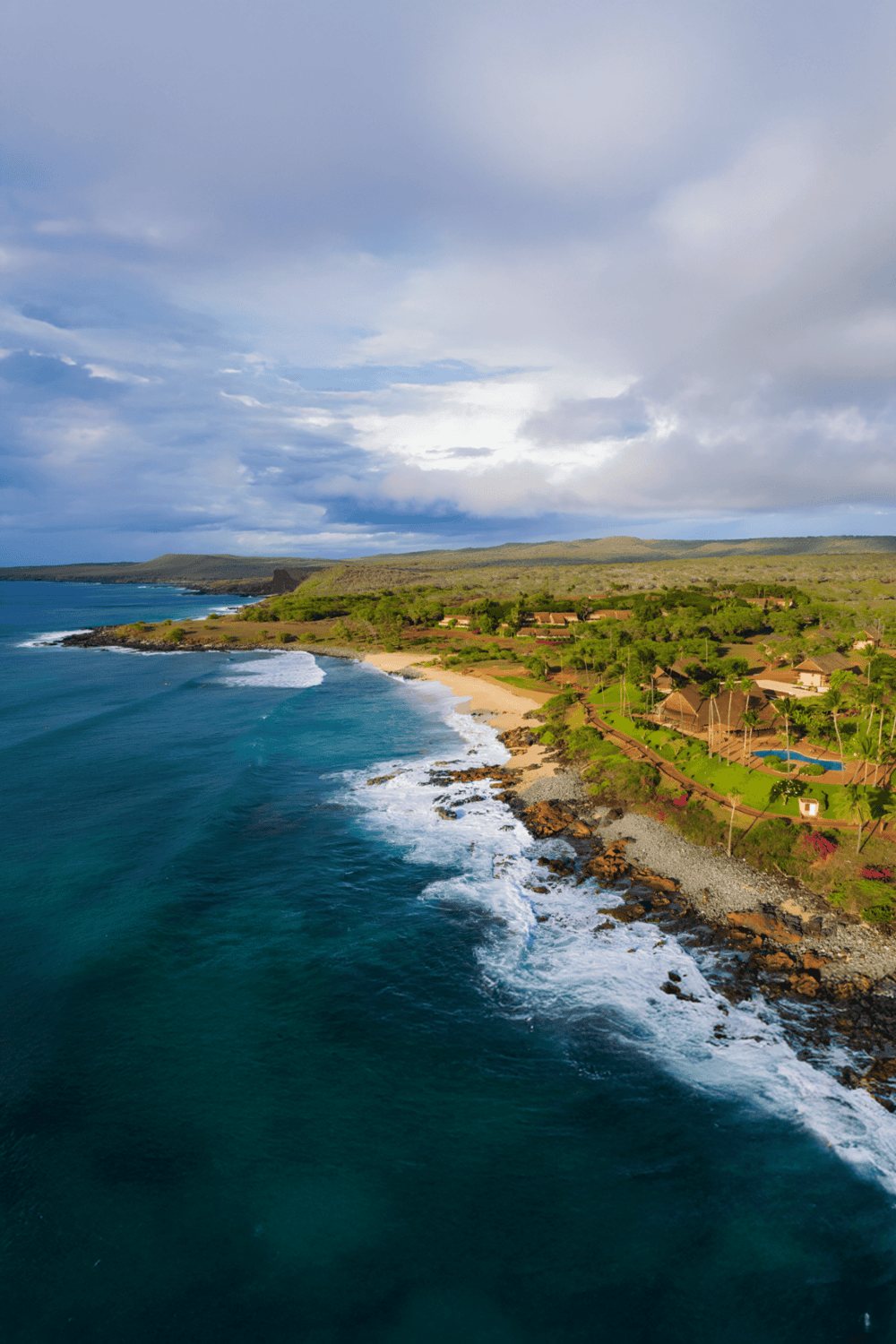 Luxury beachfront resort with ocean views, tropical gardens, and outdoor pools in Hawaii.