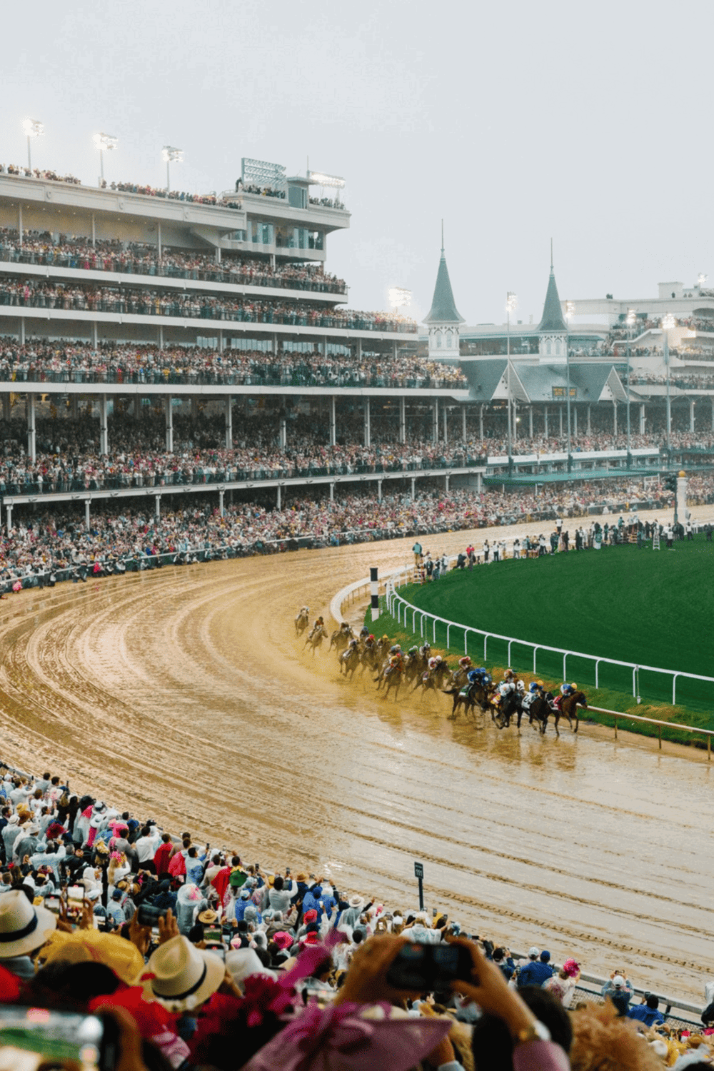 Racetrack horse racing event with excited crowd at Churchill Downs, Kentucky Derby.