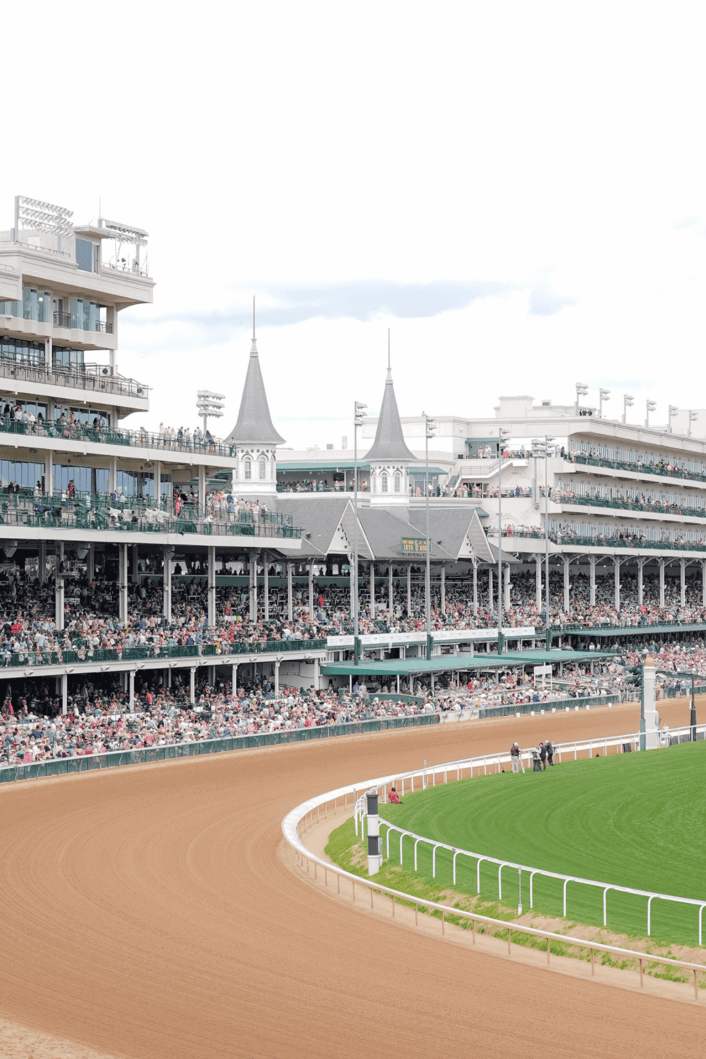 Thrilling horse race at iconic racecourse with grandstands and vibrant crowd atmosphere.