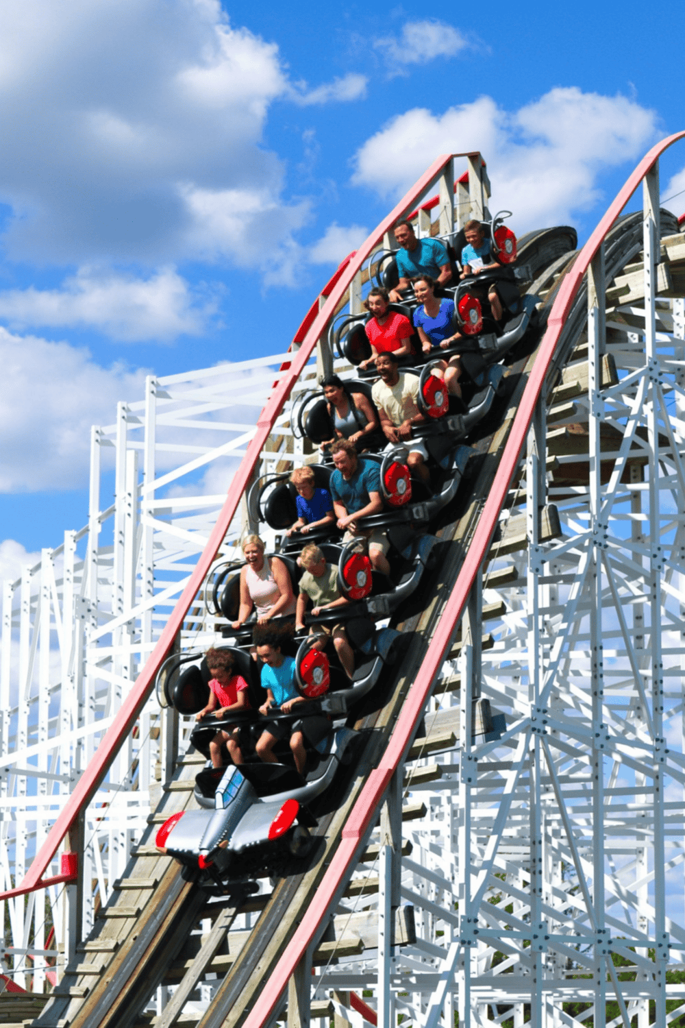 Thrilling roller coaster ride at an amusement park with joyful passengers.
